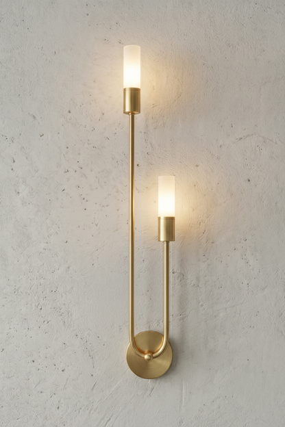 Gold wall sconce with two lights on a gray concrete wall