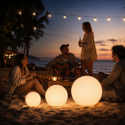People enjoying a sunset by the beach with illuminated spherical lights and string lights.